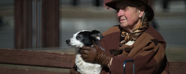 Жанчына на лаўцы з сабакам на руках Жанчына на лаўцы з сабакам на руках - Sputnik Беларусь