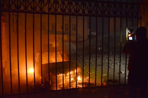 Оператор одного из грузинских телеканалов снимает сожженную в ходе беспорядков в Батуми машину - Sputnik Беларусь