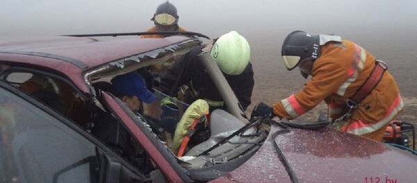 Сотрудники МЧС извлекают водителя Opel из искореженной машины - Sputnik Беларусь