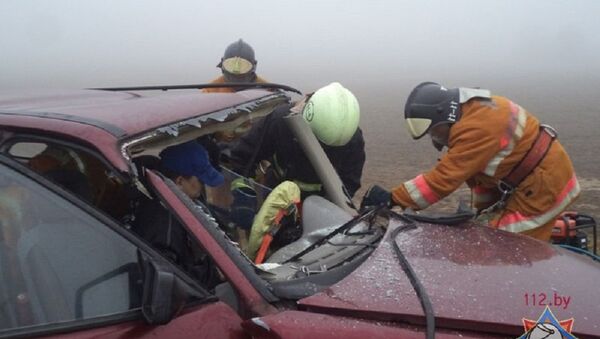Сотрудники МЧС извлекают водителя Opel из искореженной машины - Sputnik Беларусь