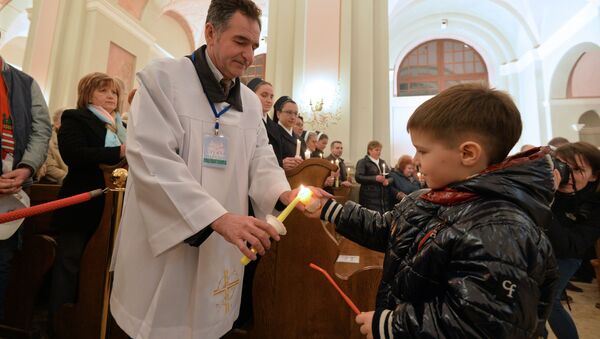 Верующие передают благодатный огонь во время Пасхального богослужения - Sputnik Беларусь