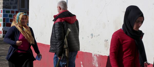 Полицейский в штатском на одном из избирательных участков в провинции Диярбакыр - Sputnik Беларусь