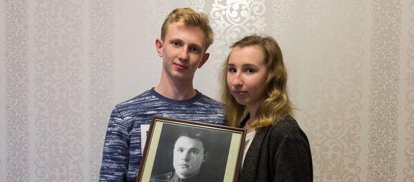Анна и Антон Сыч с портретом своего прадеда Василия Горбачева - Sputnik Беларусь