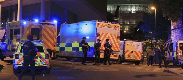 Armed police positioned near emergency vehicles after reports of an explosion at the Manchester Arena during an Ariana Grande concert in Manchester, England Monday, May 22, 2017. - Sputnik Беларусь