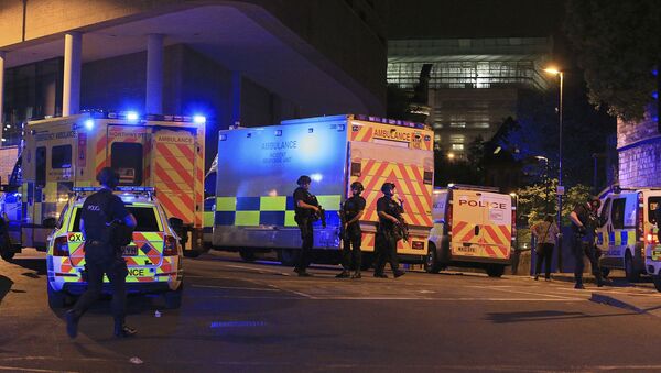 Armed police positioned near emergency vehicles after reports of an explosion at the Manchester Arena during an Ariana Grande concert in Manchester, England Monday, May 22, 2017. - Sputnik Беларусь