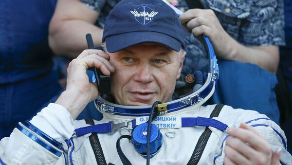 Космонавт Олег Новицкий говорит по телефону после приземления в Казахстане - Sputnik Беларусь