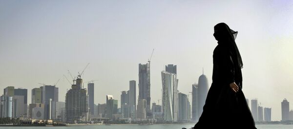 A Qatari woman walks in front of the city skyline in Doha, Qatar. - Sputnik Беларусь