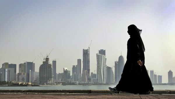 A Qatari woman walks in front of the city skyline in Doha, Qatar. - Sputnik Беларусь