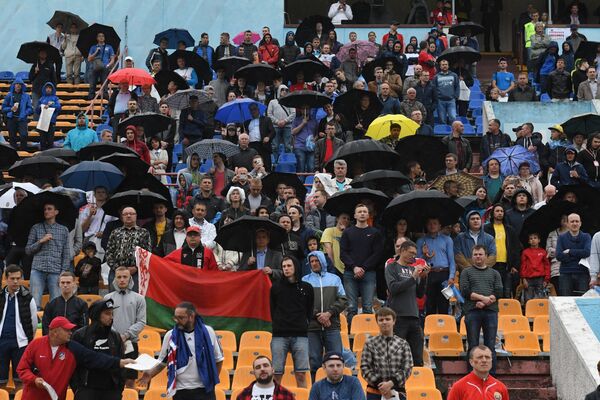 Дождь не помешал болельщикам прийти на стадион Трактор, чтобы насладиться вечерним футболом межконтинентального уровня - Sputnik Беларусь