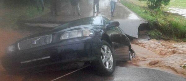 Автомобиль провалился в дыру в асфальте - Sputnik Беларусь