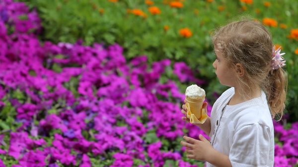 Девочка с мороженым у ковра из живых цветов в ГУМе - Sputnik Беларусь
