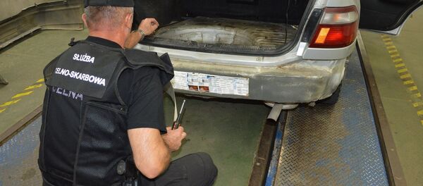 Таможенник осматривает скрытый тайник с сигаретами - Sputnik Беларусь