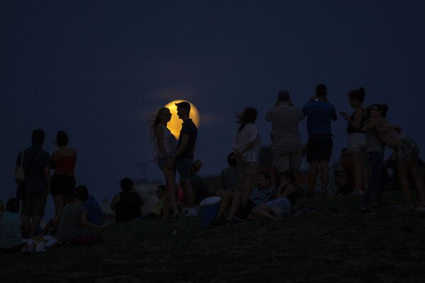 Люди наблюдают частичное лунное затмение в Мадриде - Sputnik Беларусь