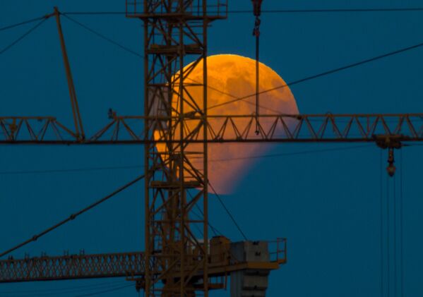Лунное затмение на фоне строительного крана в баварском городке в Германии - Sputnik Беларусь