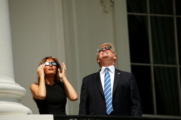 Президент США Дональд Трамп наблюдает солнечное затмение с первой леди Меланией Трамп с балкона Трумэна в Белом доме в Вашингтоне - Sputnik Беларусь