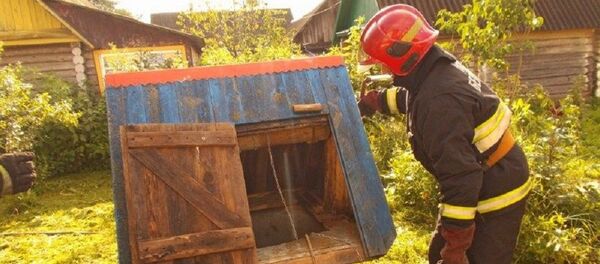 Сотрудник МЧС у колодца, в который провалился мужчина - Sputnik Беларусь