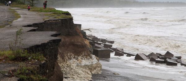 Местные жители стоят рядом с разрушенной дорогой, Доминиканская Республика - Sputnik Беларусь