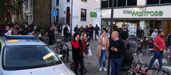 Люди стоят на улице возле станции метро Parsons Green в Лондоне - Sputnik Беларусь