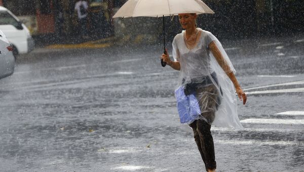 Японка под зонтом во время сильного дождя, архивное фото - Sputnik Беларусь