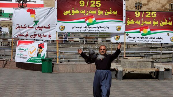 Мужчина на фоне баннеров в поддержку референдума в Курдистане - Sputnik Беларусь