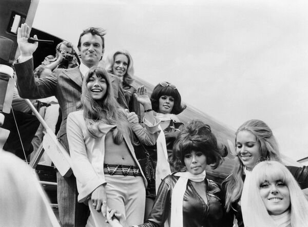 На фотографии, сделанной 30 августа 1970 года, запечатлены Хью Хефнер и его подруга актриса Барби Бентон (в центре), а также другие модели в аэропорту Ле Бурже в Париже у трапа самолета Playboy Большой зайчик. - Sputnik Беларусь