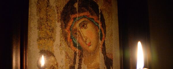 Горящая свеча на фоне вышитого изображения Казанской иконы Божьей матери - Sputnik Беларусь