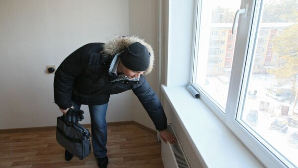 Мужчина проверят батарею - Sputnik Беларусь