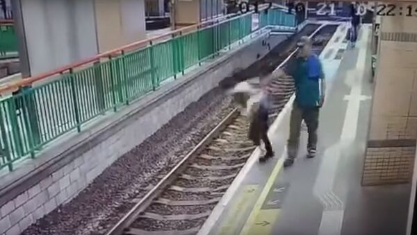 Прохожий столкнул женщину на железнодорожные пути в Гонконге - Sputnik Беларусь