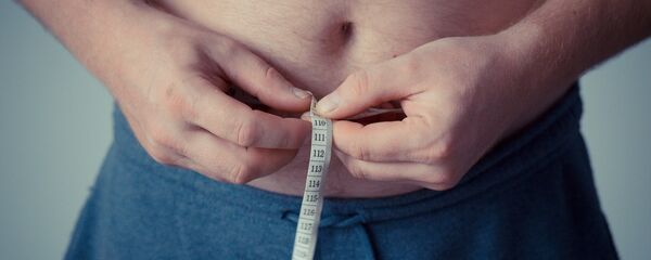 Мужчина измеряет объем талии, архивное фото - Sputnik Беларусь