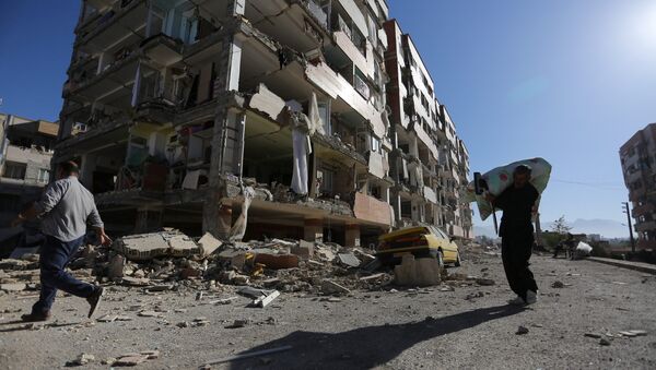 Люди проходят мимо здания, поврежденного в результате землетрясения в Иране - Sputnik Беларусь