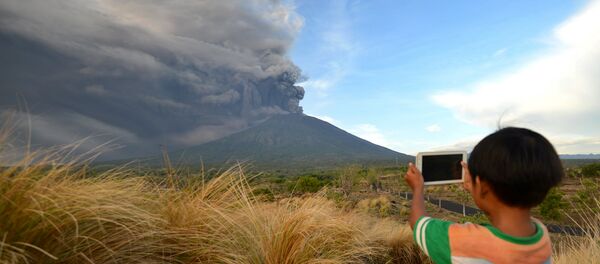 Мальчик фотографирует извержение вулкана Агунг - Sputnik Беларусь