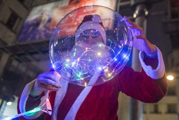 Мужчина в костюме Деда Мороза во время празднования Нового года в Санкт-Петербурге - Sputnik Беларусь
