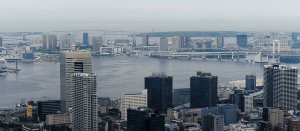 Небоскребы Toshiba Building и Hitachi Metals (на втором плане слева направо) в районе Минато в Токио, на дальнем плане - Токийский залив и радужный мост - Sputnik Беларусь