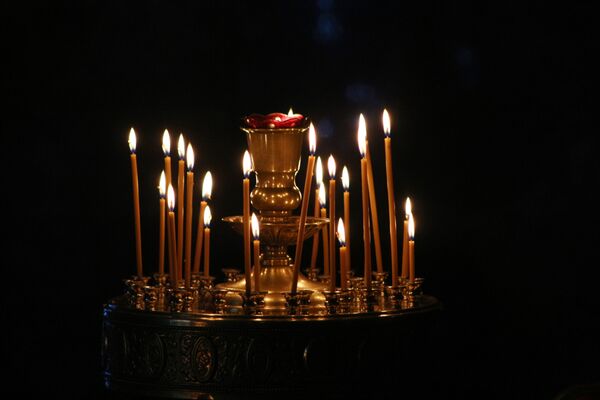 Подойдя к подсвечнику, нужно зажечь свечу от других свечей, поставить ее на свободное место. - Sputnik Беларусь