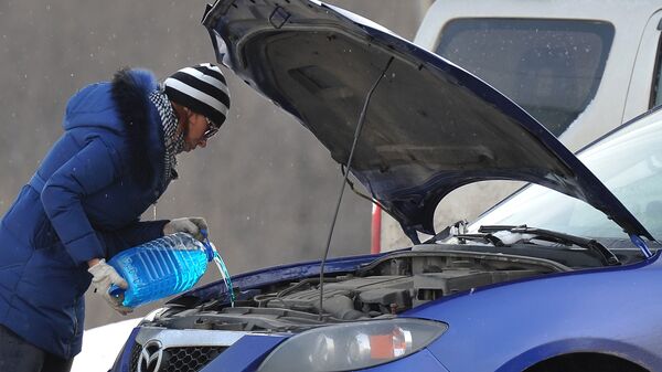 Женщина заливает незамерзающую жидкость для омывания стекол автомобиля - Sputnik Беларусь