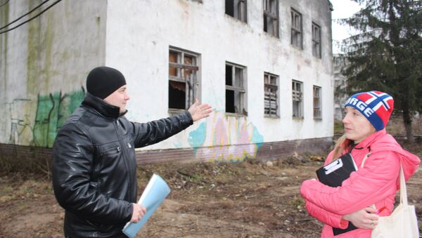Владимир и Елена показывают участок, на котором хотят построить высотку с встроенным садиком вместо обычного детского сада - Sputnik Беларусь