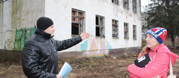 Владимир и Елена показывают участок, на котором хотят построить высотку с встроенным садиком вместо обычного детского сада - Sputnik Беларусь