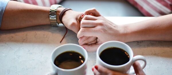 Влюбленные держатся за руки в кафе - Sputnik Беларусь