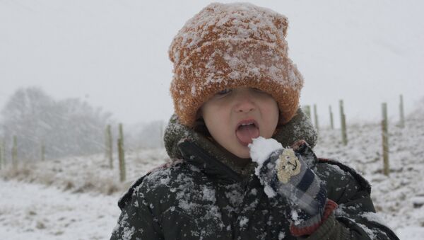 Ребенок ест снег, архивное фото - Sputnik Беларусь