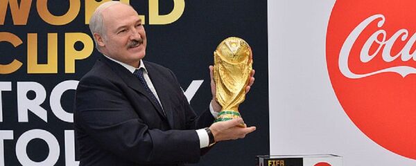 Александр Лукашенко держит в руках футбольный Кубок мира - Sputnik Беларусь