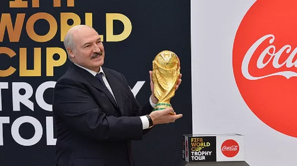 Александр Лукашенко держит в руках футбольный Кубок мира - Sputnik Беларусь