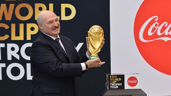 Александр Лукашенко держит в руках футбольный Кубок мира - Sputnik Беларусь