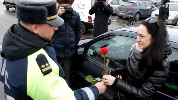 На центральной площади Витебска сотрудники госавтоинспекции дарили проезжающим женщинам цветы и колготки - Sputnik Беларусь