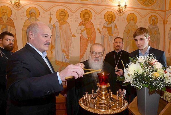 Александр Лукашенко, митрополит Филарет и Николай Лукашенко зажигают свечи - Sputnik Беларусь