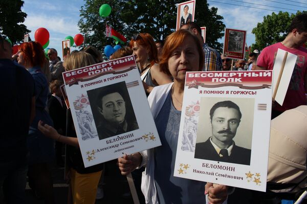 Нина Александровна несет портреты отца и дяди, которые выжили и в мирное время праздновали День Победы - Sputnik Беларусь