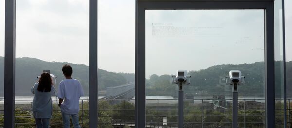 Молодые люди смотрят на территорию Северной Кореи - Sputnik Беларусь