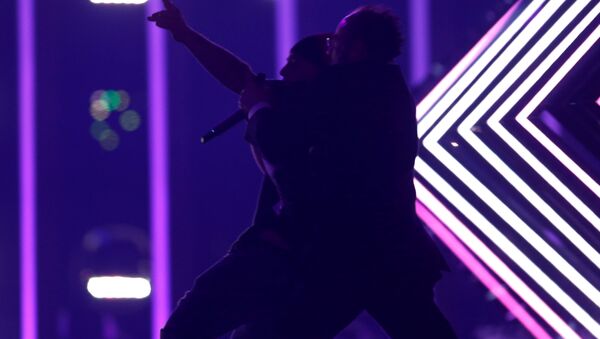 Охранник задерживает неизвестного, выбежавшего на сцену во время выступления представительницы Великобритании на Евровидении - Sputnik Беларусь