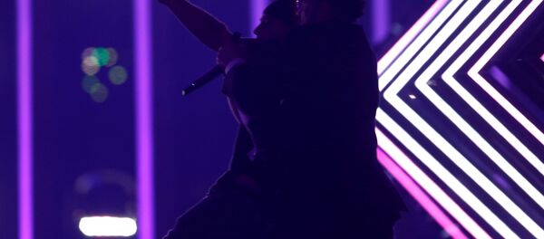 Охранник задерживает неизвестного, выбежавшего на сцену во время выступления представительницы Великобритании на Евровидении - Sputnik Беларусь