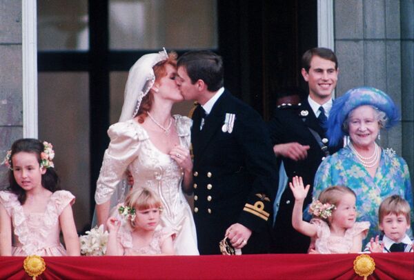 Принц Эндрю, герцог Йоркский, второй сын королевы Елизаветы II, и его невеста Сара Фергюсон на балконе Букингемского дворца после свадьбы в Вестминстерском аббатстве 24 июля 1986 года. Справа стоят королева-мать и принц Эдвард.Принц и герцогиня Йоркская развелись в 1996 году, у них двое детей: принцесса Беатрис и принцесса Евгения. Принц Эндрю седьмой в очереди на престол. - Sputnik Беларусь