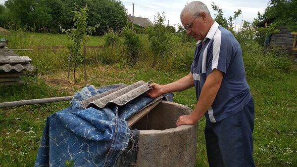 Колодец Эдуард Губко на своем участке вырыл сам, теперь не нужно далеко ходить за водой, чтобы поливать участок - Sputnik Беларусь